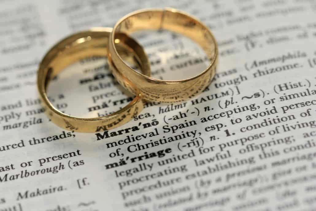 Two wedding rings on a dictionary page - representing spouse and partner sponsorship using family class
